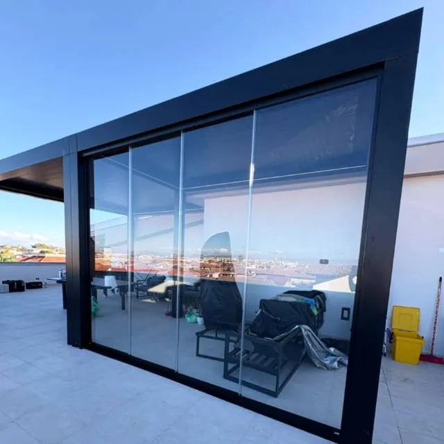 Terrazza con vetrata scorrevole a tutta altezza e struttura in alluminio scuro